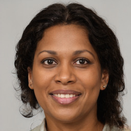 Joyful black adult female with medium  brown hair and brown eyes