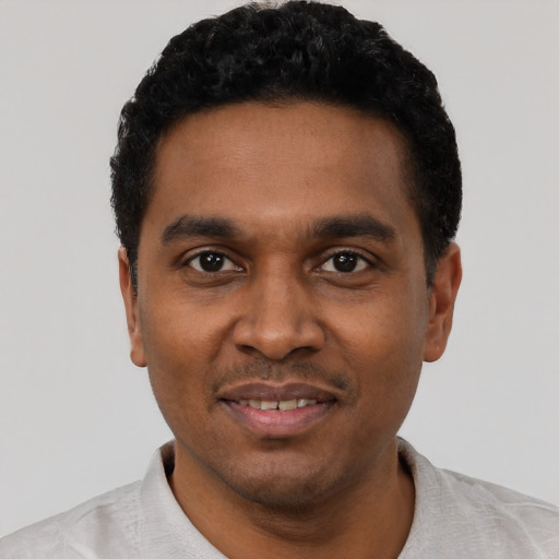 Joyful black young-adult male with short  black hair and brown eyes
