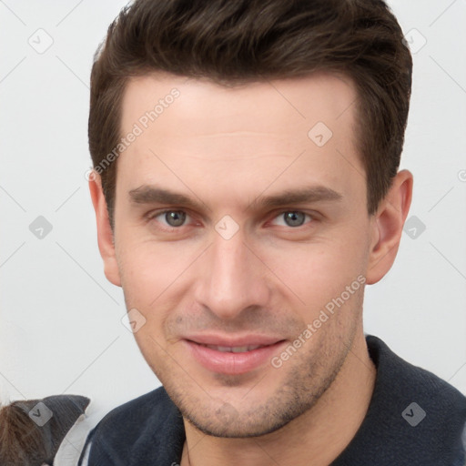 Joyful white young-adult male with short  brown hair and grey eyes