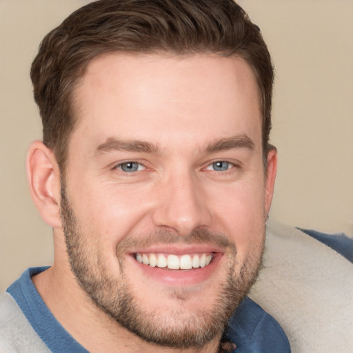 Joyful white young-adult male with short  brown hair and blue eyes