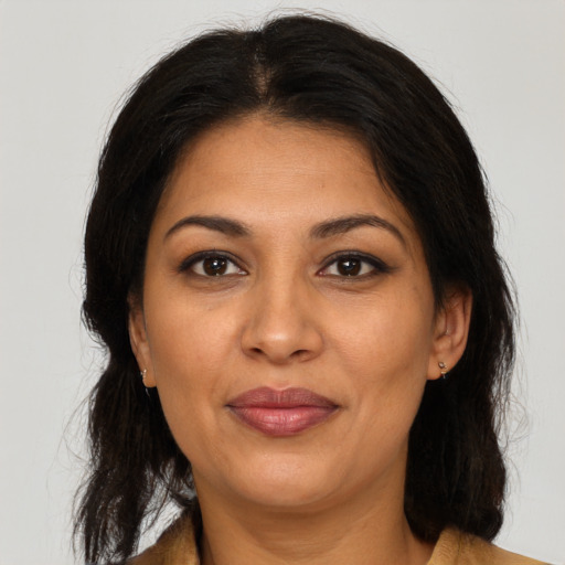 Joyful latino adult female with medium  brown hair and brown eyes
