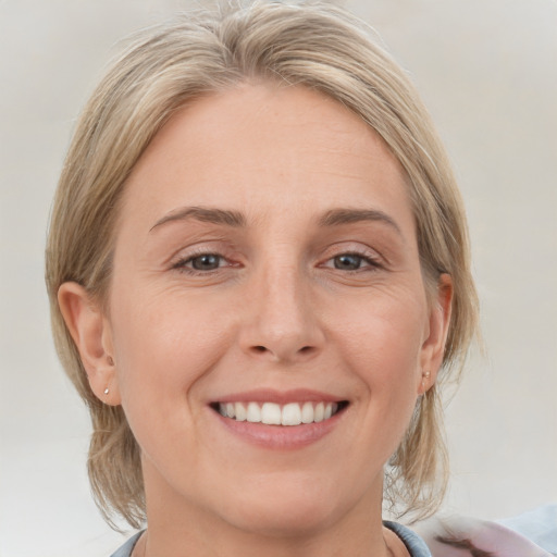 Joyful white young-adult female with medium  blond hair and brown eyes