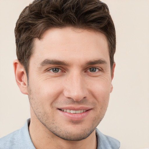 Joyful white young-adult male with short  brown hair and grey eyes