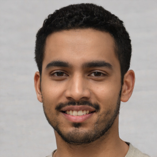 Joyful latino young-adult male with short  black hair and brown eyes