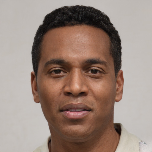 Joyful black young-adult male with short  black hair and brown eyes