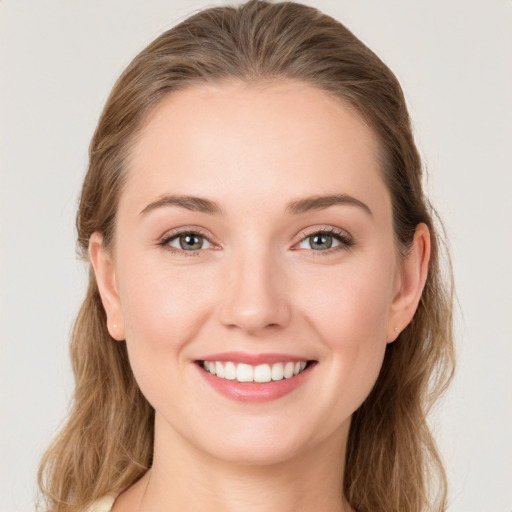 Joyful white young-adult female with long  brown hair and blue eyes