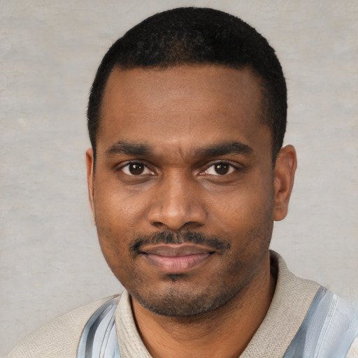 Joyful black young-adult male with short  black hair and brown eyes
