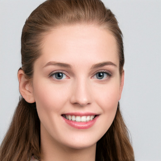 Joyful white young-adult female with long  brown hair and blue eyes