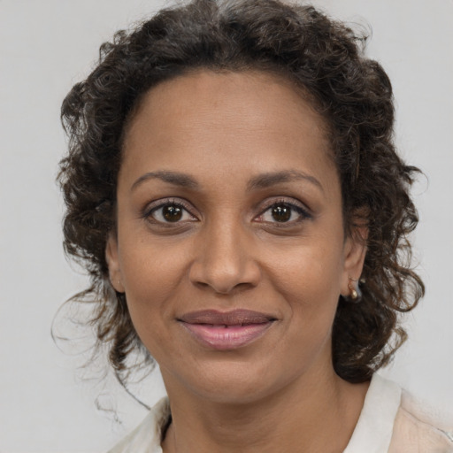 Joyful black adult female with medium  brown hair and brown eyes