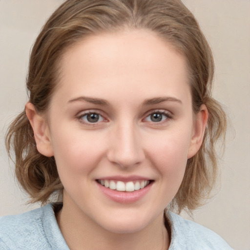 Joyful white young-adult female with medium  brown hair and blue eyes