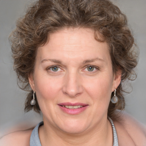 Joyful white adult female with medium  brown hair and blue eyes