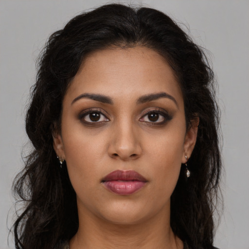 Joyful latino young-adult female with long  brown hair and brown eyes