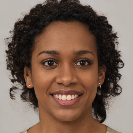 Joyful black young-adult female with medium  brown hair and brown eyes