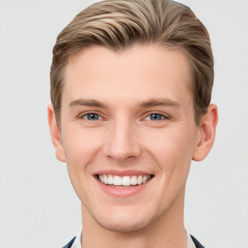 Joyful white young-adult male with short  brown hair and grey eyes