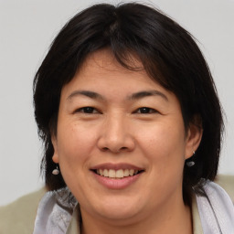 Joyful asian adult female with medium  brown hair and brown eyes