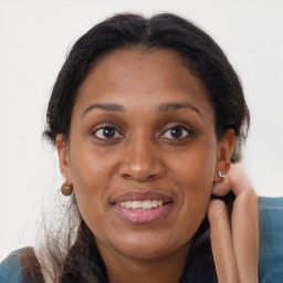 Joyful black adult female with long  brown hair and brown eyes