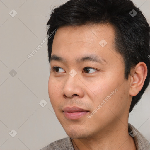 Joyful asian young-adult male with short  black hair and brown eyes