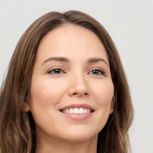 Joyful white young-adult female with long  brown hair and brown eyes