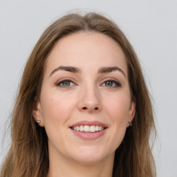 Joyful white young-adult female with long  brown hair and green eyes