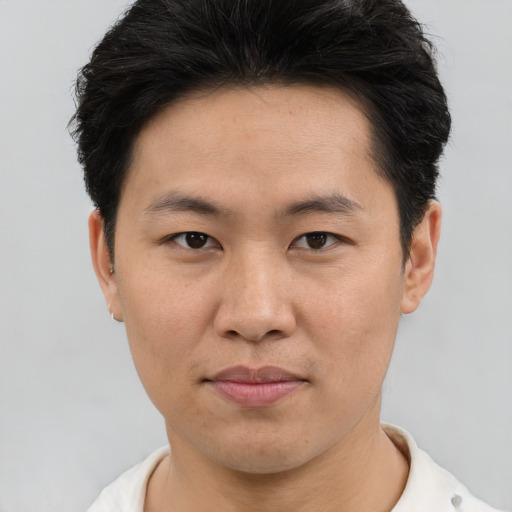 Joyful asian young-adult male with short  brown hair and brown eyes
