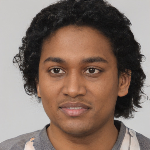 Joyful black young-adult male with short  black hair and brown eyes
