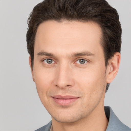 Joyful white young-adult male with short  brown hair and brown eyes