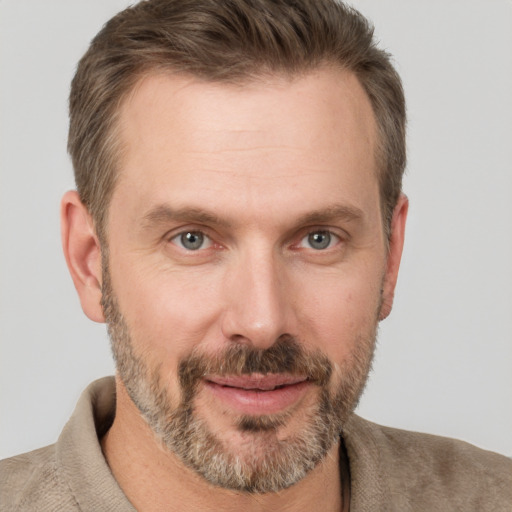 Joyful white adult male with short  brown hair and grey eyes