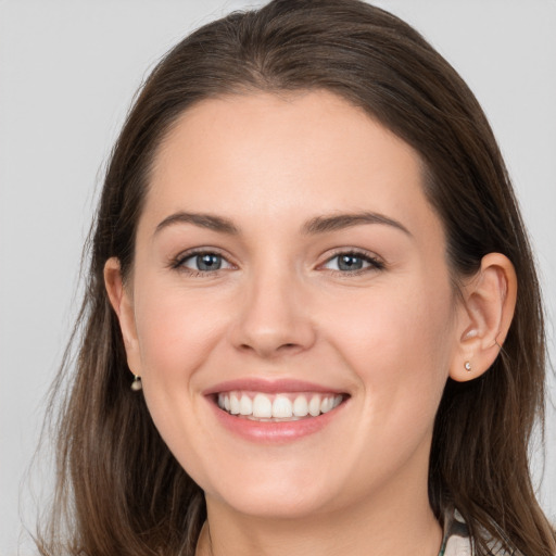 Joyful white young-adult female with long  brown hair and grey eyes