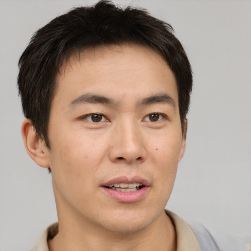 Joyful asian young-adult male with short  brown hair and brown eyes