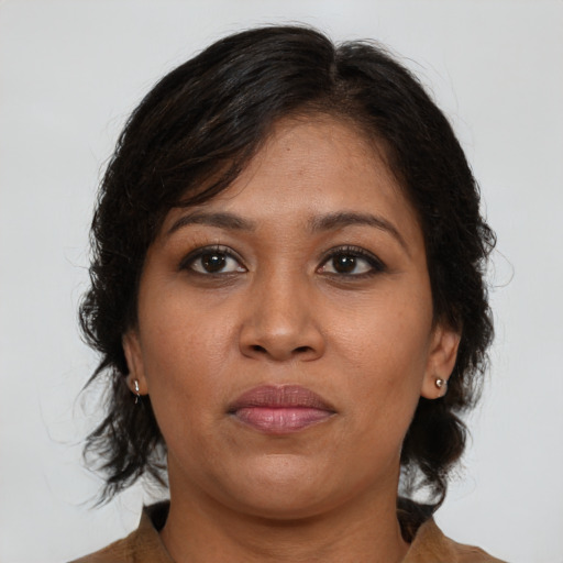 Joyful black adult female with medium  brown hair and brown eyes