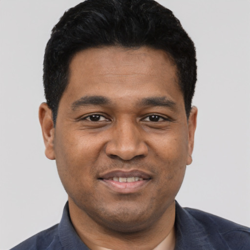 Joyful black young-adult male with short  black hair and brown eyes