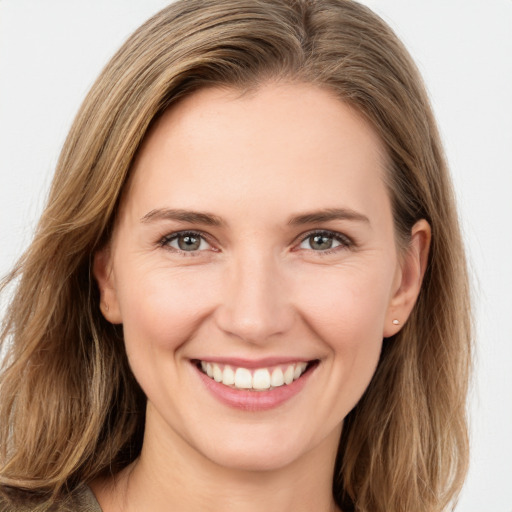 Joyful white young-adult female with long  brown hair and green eyes