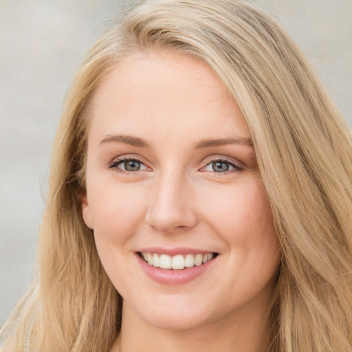 Joyful white young-adult female with long  brown hair and blue eyes