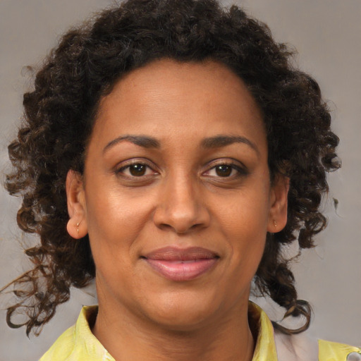 Joyful black adult female with medium  brown hair and brown eyes