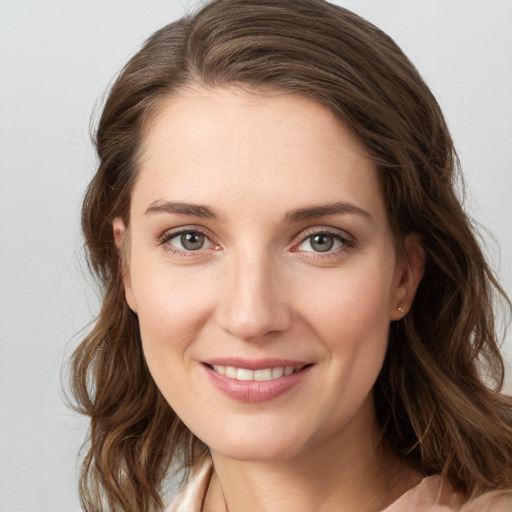 Joyful white young-adult female with long  brown hair and blue eyes