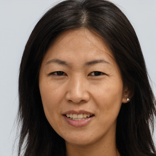 Joyful asian adult female with long  brown hair and brown eyes