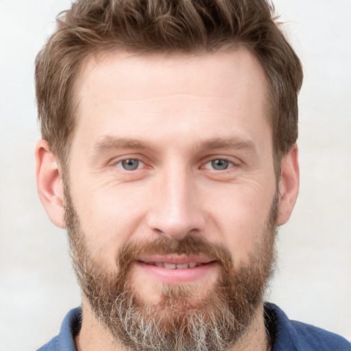 Joyful white adult male with short  brown hair and grey eyes