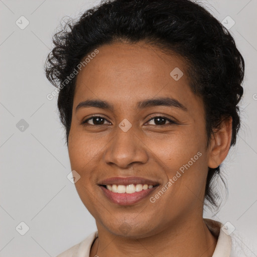 Joyful black young-adult female with short  black hair and brown eyes