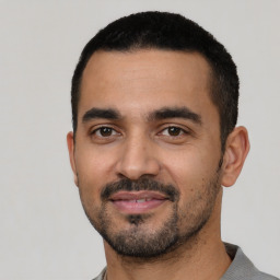 Joyful latino young-adult male with short  black hair and brown eyes