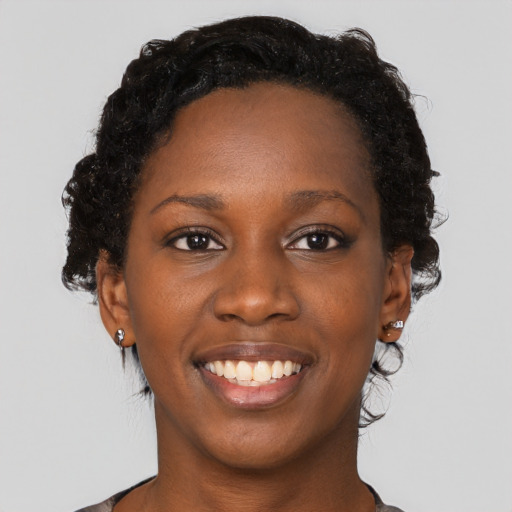 Joyful black young-adult female with medium  brown hair and brown eyes