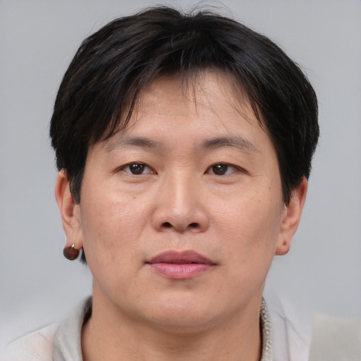 Joyful asian adult male with short  brown hair and brown eyes