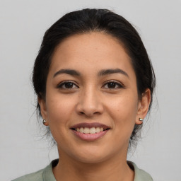 Joyful latino young-adult female with medium  brown hair and brown eyes