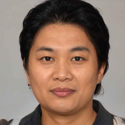 Joyful asian adult male with medium  black hair and brown eyes