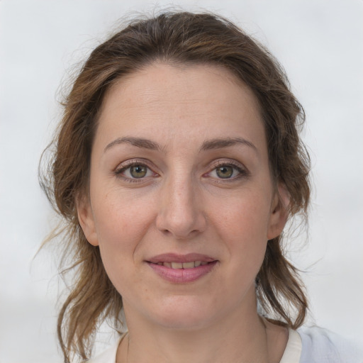 Joyful white adult female with medium  brown hair and grey eyes