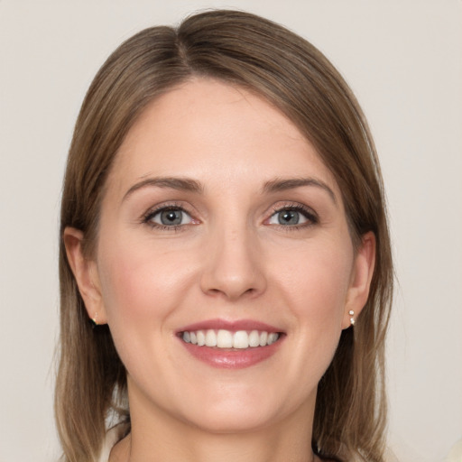 Joyful white young-adult female with medium  brown hair and grey eyes