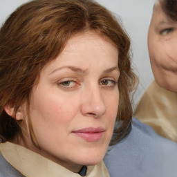 Joyful white young-adult female with medium  brown hair and blue eyes