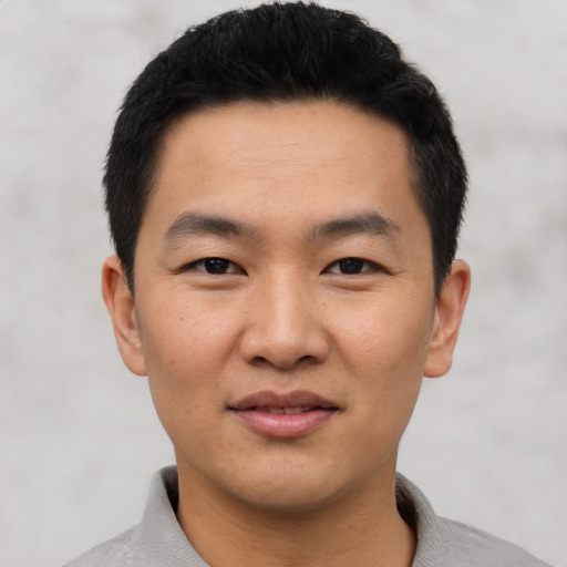 Joyful asian young-adult male with short  black hair and brown eyes