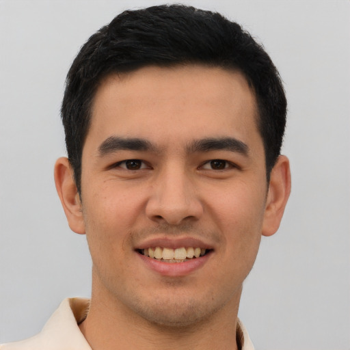 Joyful latino young-adult male with short  brown hair and brown eyes