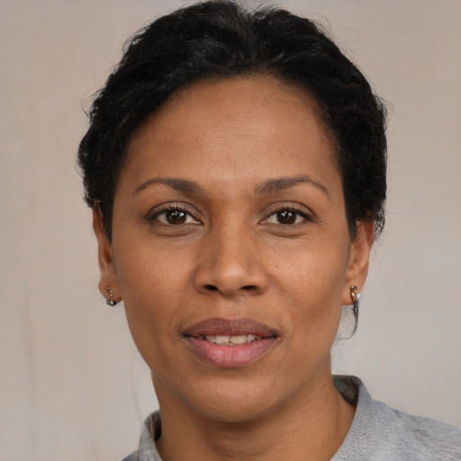 Joyful black adult female with short  black hair and brown eyes