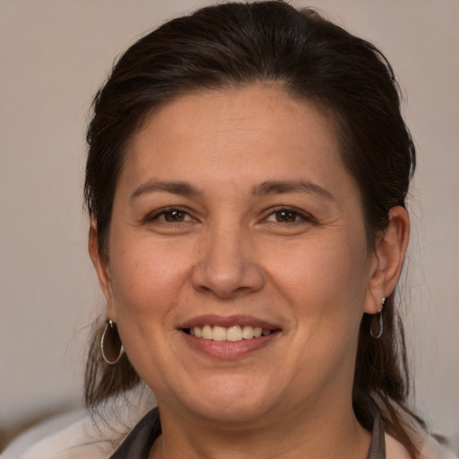 Joyful white adult female with medium  brown hair and brown eyes